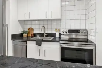 Kitchen with custom cabinets, modern tile work and new appliances
