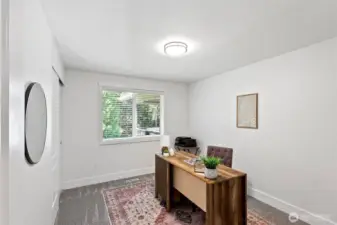 Bedroom 2, located on the main level, currently staged as a home office with new plush carpet.