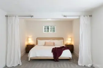 Cozy alcove comfortably fits king sized bed in primary bedroom.