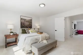 Grand primary bedroom at the top of the stairs featuring double doors, new millwork, carpet, paint lighting and hardware.