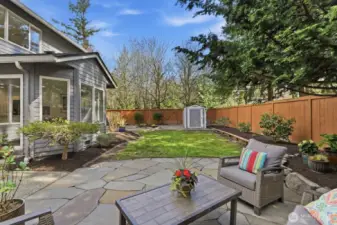 Spacious backyard with mature landscaping, ideal for gardening, play, and entertaining.