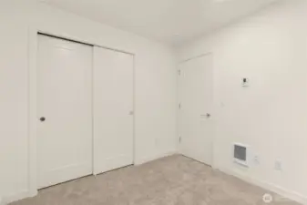 This room features thoughtful storage and enough wall space for a gallery or a workspace setup.