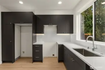 Your future kitchen is equal parts sleek and functional. Matte black cabinets, quartz countertops, and a giant window to gaze out.