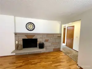 Living room with wood burning fireplace and original hardwood floors.