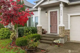 Japanese Maple stands among nice landscaping at this pillared front step--a welcoming entry!
