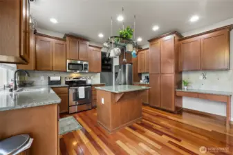 Coffee bar inset near fridge, tall pantry cabinets for ample storage, and desk space/charging station for ultra convenience!