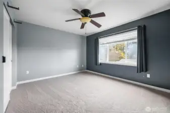 Bedroom #4 (large enough to be a bonus/flex room) in front of home, with large window and ceiling fan.