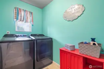 Whimsical and happy laundry room is conveniently situated upstairs (where all the clothes are!), with window for natural light and room for hamper/supplies.