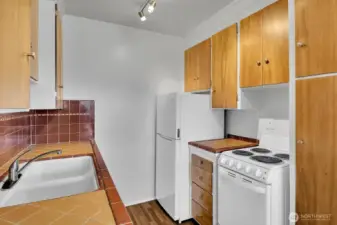 Original mahogany wood cabinets and tile counters.  Appliances are all newer with recently replaced Hot water tanks in each unit.