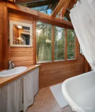 Upstairs full bath looks out onto the forest.