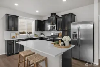 Beautiful quartz countertops, birch cabinets with large hardware, and island eating.