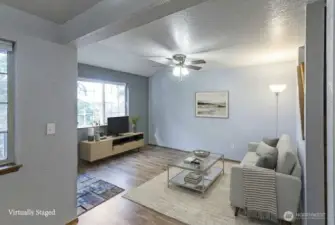 Open main floor plan creating a bright and welcoming space. Features durable laminate flooring throughout, complemented by tasteful and modern updates, enhancing the overall appeal and comfort of the home.