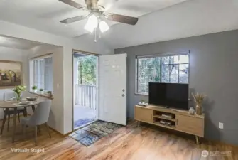 Living and dining room with a private covered balcony offering views of a greenbelt. This space is perfect for relaxing and enjoying the outdoors.