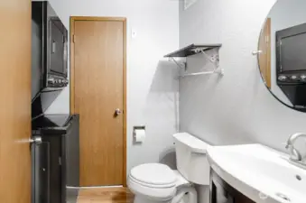 Main floor half bath features a newer vanity. The utility room includes a stackable washer and dryer. A door leads to the HVAC system and new water heater.