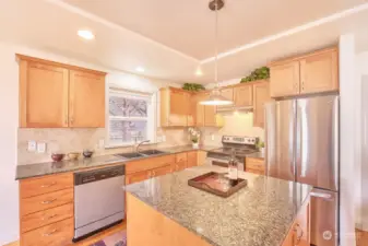 Kitchen has stainless appliances, tall counters topped with beautiful granite.