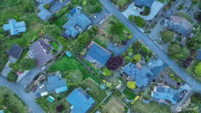 Centered off of Colman circle drive - a micro-community within the Cape George larger community.  Two fenced garden areas - in back and side to left. Parking area for lower level. Driveway continues up under large reddish tree.  Entry gate to home at top of drive.