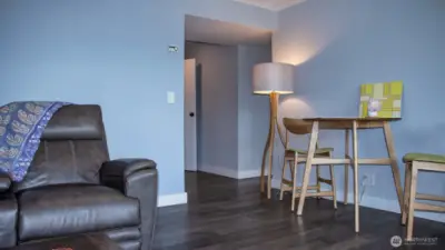 Multi-purpose room looking towards interior door to upper level. Hallway to right goes to bedroom and kitchenette.