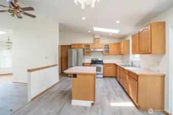 View from the dining area into the kitchen, where a skylight adds extra brightness.