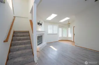 Stairway opens to the upper level, showcasing the home’s light-filled design.