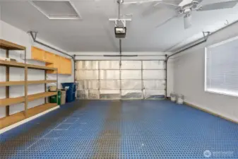 large Spacious 2-car garage featuring a ceiling fan and smart storage solutions.
