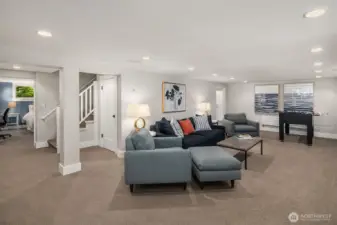 The lower-level media room boasts ceiling speakers and custom-designed lighting, all part of a fully renovated and functional basement.