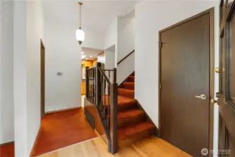 View of entry with coat-closet. Living room directly to the left, kitchen straight ahead, stairs to 2nd floor and around to the right leads to stairs to lower level.