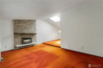 Unstaged living room, natural gas fireplace and partial dining room view.