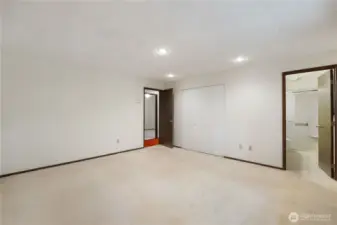 Upstaged Primary bedroom with partial view of 3/4 bathroom.