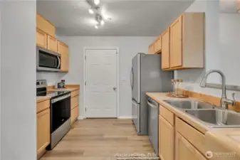 Kitchen features stainless steel appliance and opens to the living and dining areas.