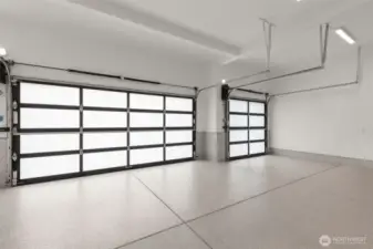 3 car garage with metal and glass doors, epoxy floors and finished walls