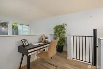 Upper level area perfect for home office, overlooking lower space and framed with windows.