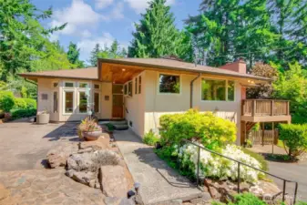 Welcoming front approach with stamped concrete patio and tiered beds.