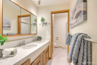 Full Hall Bathroom with dual sinks and pocket door to separate toilet/shower space