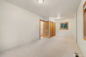 Large room with closet and multiple windows.