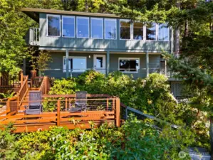 nestled in trees. The sun comes first to the "C-Deck", where you can enjoy a cup of coffee and watch the seabirds fly over sparkling waters.