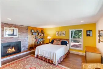 Bedroom #3 on the lower level. It has a wood burning fireplace also, and a window out onto the lower level deck and west to the water.