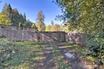 The approach to the property from the shared driveway. That large gate has a roller on the bottom of it to get it open.