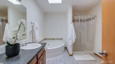 Unwind in your private en suite featuring a soaking tub, separate walk-in shower, and a serene layout