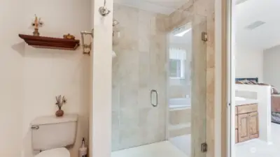 Separate area in the en-suite offers a glass doored walk-in shower.