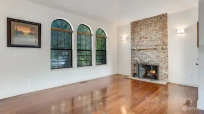 Beautiful hardwoods and a wood burning fireplace with a grand brick surround give this space the perfect ambiance.