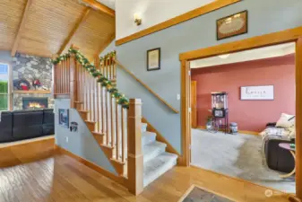 Welcome to our home! Engineered distressed oak floors are featured in the foyer & kitchen. To the right, a spacious den. An open staircase accesses the upper level bedrooms.