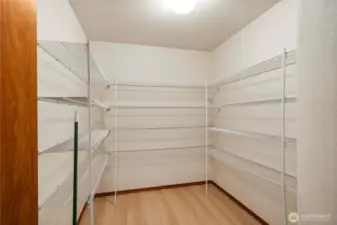 A spacious walk-in pantry offers plenty of room for all your kitchen essentials.