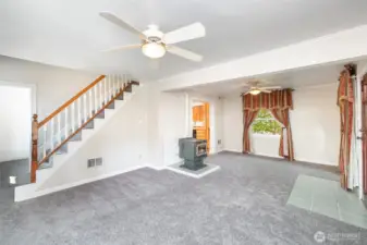 Living room features new carpet, ceiling fans, large windows and fireplace.