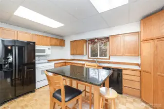 The large kitchen features warm-toned cabinetry, ample counter space, abundant storage, and pantry.