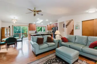Inside, a skylight, expansive windows, and a patio door bathe the space in natural light, creating an inviting, sun-washed ambiance throughout.