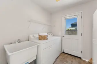Large main floor laundry room with utility sink and access to the backyard.   (W&D stay)