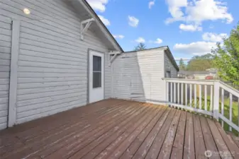 Back deck and man door leading into one car garage