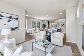 Open-concept main floor featuring laminate wood flooring, recessed lighting, and seamless flow from the bright living room to the large kitchen.