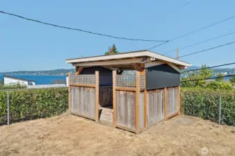 A charming covered gazebo sits in the yard, perfectly placed while offering shade, privacy, and extra storage space.