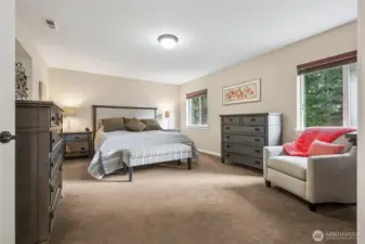 The spacious primary suite offers a true retreat, with room for a sitting area or reading nook. A calming space to unwind at the end of the day.